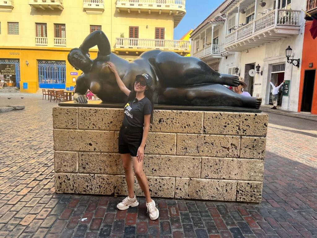 Roxeus touching the Gorda Gertrudis statue in Plaza Santo Domingo, Cartagena, Colombia.