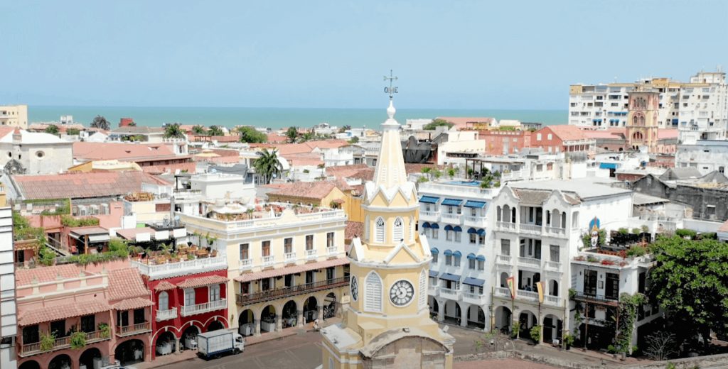 View of the Torre del Reloj and colonial buildings in Cartagena's Old Town with the Caribbean Sea in the background.